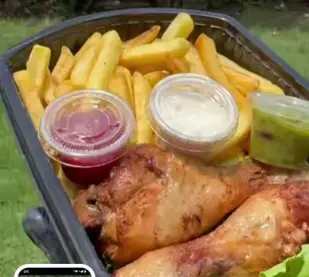 Un plat de frite avec 2 cuisses de poulets
